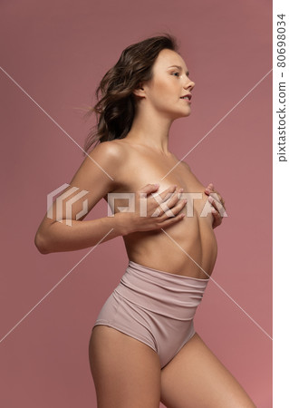 Portrait of beautiful attractive caucasian naked woman isolated on pink studio background. Natural beauty, treatment, healthcare, wellness, well-kept skin concept. Portrait of beautiful attractive caucasian naked woman isolated on pink studio background. Natural beauty, treatment, healthcare, wellness, well-kept skin concept. 80698034