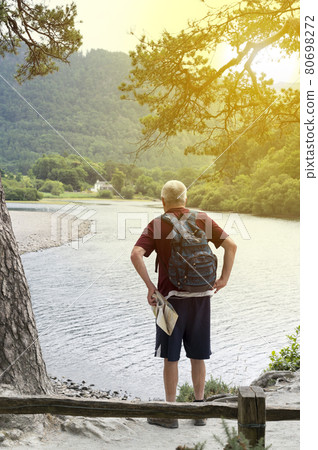 Keswick, English Lake District, U.K. 28 July, 2021. A man from behind at point view of the lake Keswick, English Lake District, U.K. 28 July, 2021. A man from behind at point view of the lake 80698272
