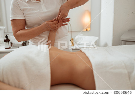 Masseuse massaging woman hand in spa salon 80698646