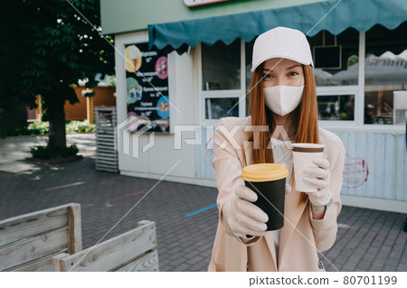 Food and drink businesses during coronavirus pandemic. Coffee to go takeaway cup in female hands in gloves. Restaurants, pubs, bars, nightclubs and takeaway services working safely during coronavirus 80701199