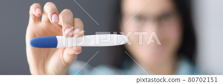 Woman holds pregnancy test in her hand 80702151