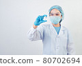 Professional scientist or doctor holding Covid-19 vaccine vial in hand of at laboratory for treatment with mask gloves and lab coat on white background. Health business and industry concept. 80702694