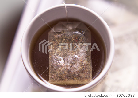 White cup with infusion and tea bag 80703088
