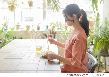 Young woman eating in the room 80703348