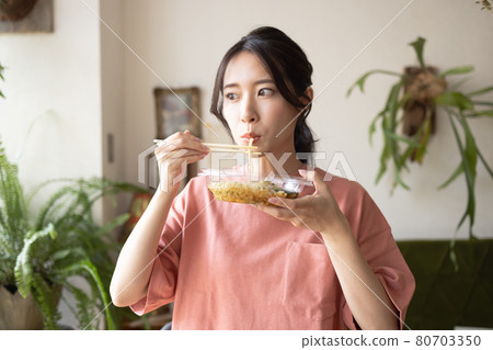 在房間裡吃的年輕女子 在房間裡吃的年輕女子 80703350