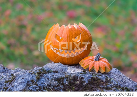 Scary smiling face halloween pumpkin on a stone 80704338