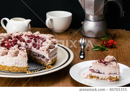 Portion of pomegranate cheesecake taking from the whole that garnished with cream and pomegranate seed. Portion of pomegranate cheesecake taking from the whole that garnished with cream and pomegranate seed. 80705355