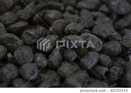 Black tektite stone or meteorite as background 80705543