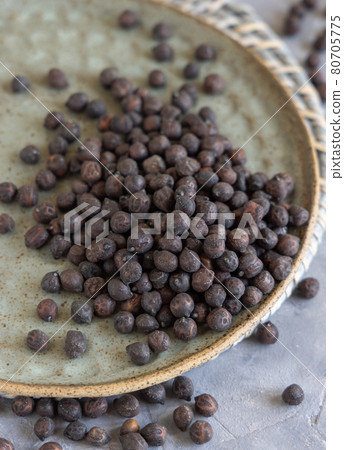 Plate of black chickpea on grey table closeup Plate of black chickpea on grey table closeup 80705775