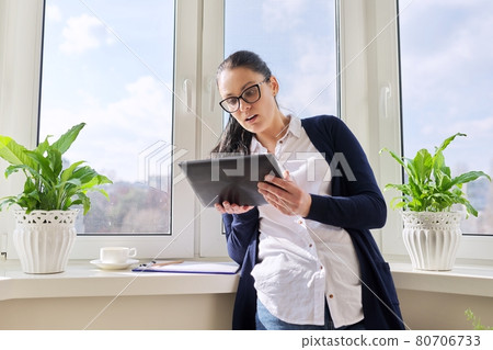 Serious business woman talking on video call, using digital tablet Serious business woman talking on video call, using digital tablet 80706733