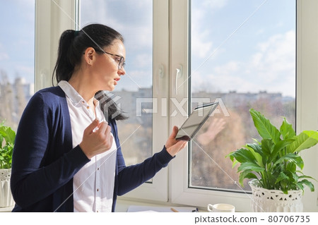 Serious business woman talking on video call, using digital tablet Serious business woman talking on video call, using digital tablet 80706735