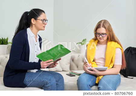 Female teacher studying individually with teenage girl Female teacher studying individually with teenage girl 80706760
