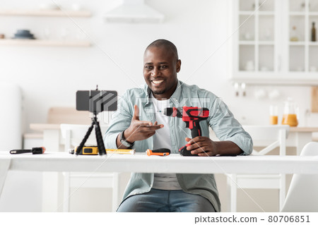 African american handyman recording video review of instruments, showing electric screwdriver and talking to smartphone 80706851