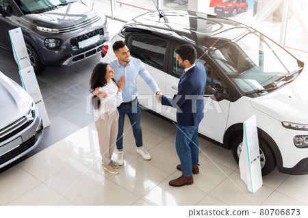 Young middle-eastern couple visiting automobile showroom or exhibition Young middle-eastern couple visiting automobile showroom or exhibition 80706873