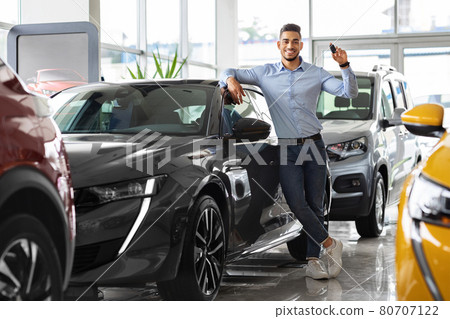 Stylish arab man holding key from automobile and smiling 80707122