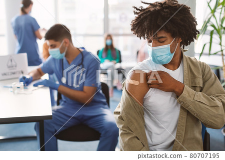Black Guy Showing Vaccinated Arm With Adhesive Bandage In Clinic Black Guy Showing Vaccinated Arm With Adhesive Bandage In Clinic 80707195