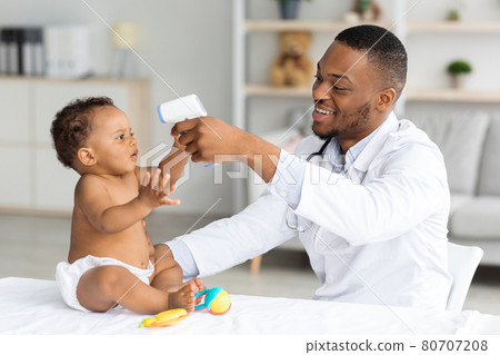 Smiling Black Male Doctor Checking Newborn Baby Body Temperature With Infrared Thermometer 80707208