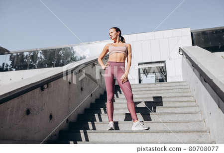 Young slim sportive caucasian woman working out, doing fitness, yoga on the stairs outdoors. Young slim sportive caucasian woman working out, doing fitness, yoga on the stairs outdoors. 80708077