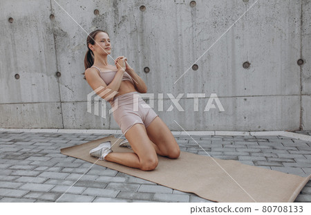 One young slim sportive caucasian woman working out, doing fitness, yoga on the city street. One young slim sportive caucasian woman working out, doing fitness, yoga on the city street. 80708133