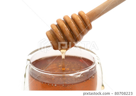 Honey with wooden dipper stick isolated on white background. Sweet food. Honey bees and wax. Nectar. Honey with wooden dipper stick isolated on white background. Sweet food. Honey bees and wax. Nectar. 80708223