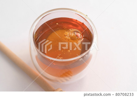 Honey with wooden dipper stick isolated on white background. Sweet food. Honey bees and wax. Nectar. 80708233
