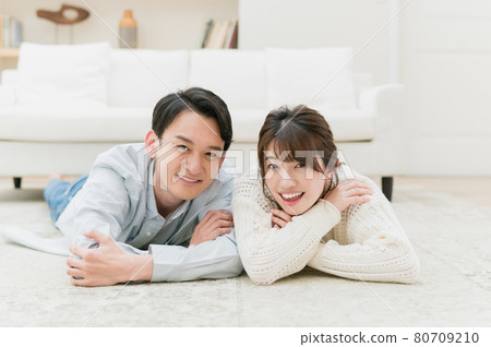 A good young couple lying down in the living room A good young couple lying down in the living room 80709210