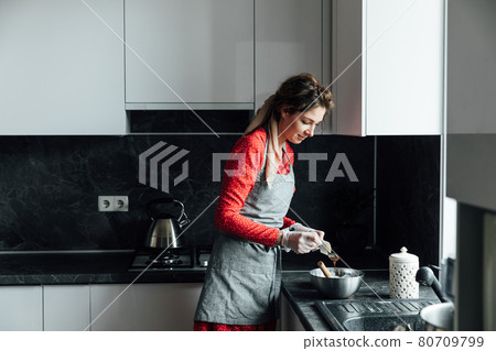 beautiful woman cooks sweet delicious dessert in the kitchen 80709799