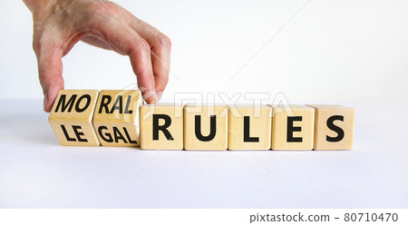 Legal or moral rules symbol. Businessman turns wooden cubes and changes words legal rules to moral rules on a beautiful white background. Business and legal or moral rules concept. Copy space. Legal or moral rules symbol. Businessman turns wooden cubes and changes words legal rules to moral rules on a beautiful white background. Business and legal or moral rules concept. Copy space. 80710470