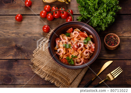 Fettuccine pasta with shrimp, cherry tomatoes, sauce, spices and herbs Fettuccine pasta with shrimp, cherry tomatoes, sauce, spices and herbs 80711022