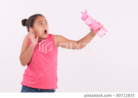 Little girl holding a bottle of water with surprised expression Little girl holding a bottle of water with surprised expression 80711655