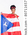 Excited looking latina woman holding the flag of Puerto Rico: Patriotic concept 80711657