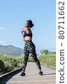 Afro american woman stretching on a wooden runway outdoors: Selective focus. Exercise concept 80711662