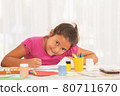 Smiling little girl drawing and looking at camera in class 80711670