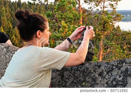 Woman make little stone pyramids in Karelija Woman make little stone pyramids in Karelija 80711892