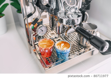 Two macchiato shots in espresso cups on coffee machine at home - white apartment kitchen, modern interior lifestyle 80711977
