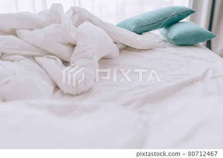 Unmade bed with pillows and messy white sheets Unmade bed with pillows and messy white sheets 80712467