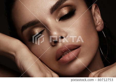 Beautiful girl with bright fashionable make-up and unusual gold accessories. Beauty face. 80712753