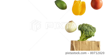 Isolated on white background levitating vegetables tomato, pepper, avocado, onion, broccoli over a paper bag Isolated on white background levitating vegetables tomato, pepper, avocado, onion, broccoli over a paper bag 80712820