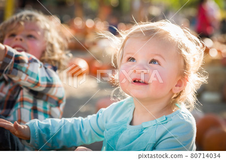 Sweet Little Boy Plays with His Baby Sister in a Rustic Ranch Setting at the Pumpkin Patch. Sweet Little Boy Plays with His Baby Sister in a Rustic Ranch Setting at the Pumpkin Patch. 80714034