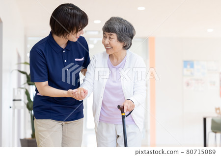 Nursing image: Senior woman walking with a cane and a caregiver Photographing cooperation: Japanese language school attached to Chuo Institute of Technology 80715089