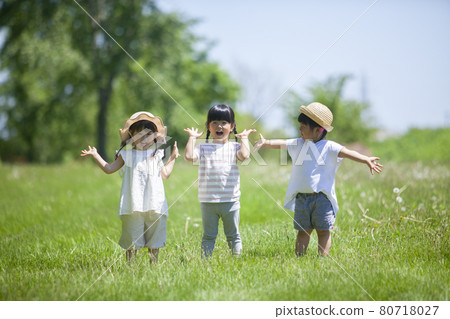 Three girls playing in a lawn park 80718027
