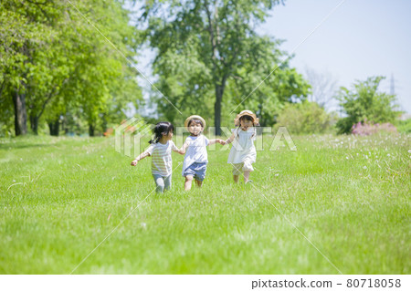 Three girls playing in a lawn park Three girls playing in a lawn park 80718058