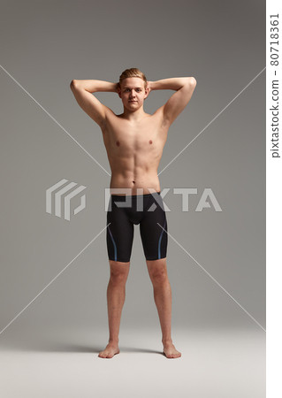 Portrait of a swimmer in a cap and mask, half-length portrait, young athlete swimmer wearing a cap and mask for swimming, copies of space, gray background 80718361