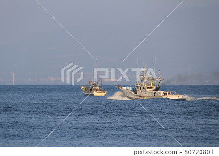 A fishing boat leaving the harbor for a fishing ground in the evening of summer 80720801