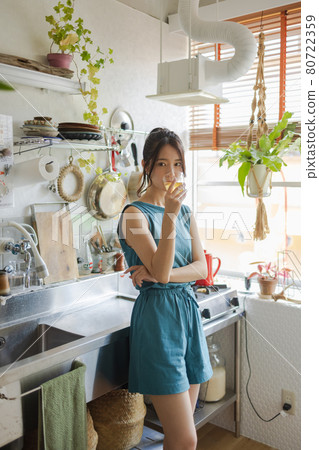 一名婦女在廚房裡喝茶 一名婦女在廚房裡喝茶 80722359