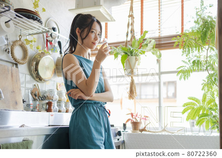 A woman drinking tea in the kitchen A woman drinking tea in the kitchen 80722360