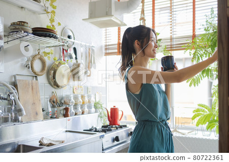 一名婦女飲用的咖啡在廚房裡 一名婦女飲用的咖啡在廚房裡 80722361