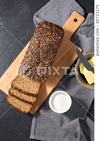 close up of bread, butter, knife and salt on towel 80723275