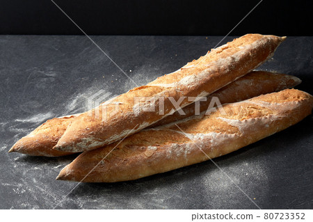 baguette bread on table over dark background 80723352