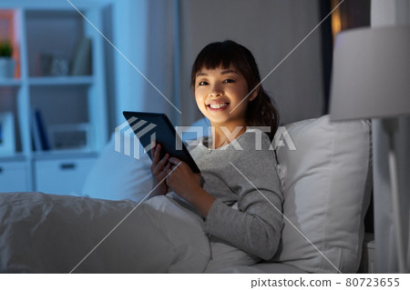 asian woman with tablet pc in bed at home at night 80723655